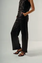 Pantalón de vestir negro con estampado jacquard floral, tiro alto y corte recto. Se combina con un chaleco a juego.