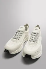 Zapatilla deportiva color crudo para uso diario y carreras ligeras. Parte superior de tejido de punto transpirable con puntera y talón recubiertos de material Shield Protect Max. Ajuste con cordones, tirador trasero y plantilla OrthoLite® extraíble. Entresuela con tecnología Spume Foam V3 y suela de goma.