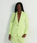 Blazer color verde lima, de corte clásico, con cuello solapa, abotonado sencillo, bolsillos delanteros con solapa y puños ajustados con botón.