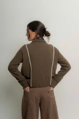 Saco de lana italiano azul con cuello en V, cierre con botones y ribetes en contraste.