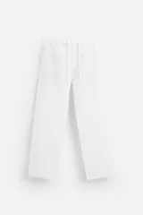 Pantalón blanco de corte recto y relaxed fit, confeccionado en tejido de mezcla de algodón y lino. Cuenta con cintura elástica ajustable con cordón, bolsillos frontales y traseros de vivo.