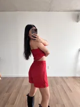 Top rojo con breteles finos, escote en V y detalle de nudo en el centro.