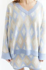 Sweater de lana color beige con diseño geométrico de rombos en tonos beige y blanco, cuello en V y corte holgado.