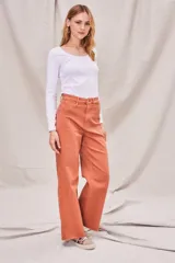 Jeans de corte wide leg color ladrillo, con tiro medio y composición de algodón peinado y elastano.