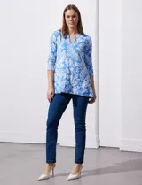 Blusa amarilla estampada con motivos florales en blanco, escote en V y mangas tres cuartos.