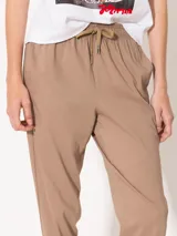 Pantalón babucha color café, confeccionado en algodón liviano, con cintura elastizada, cordón ajustable, bolsillos laterales y botamangas levemente entalladas.