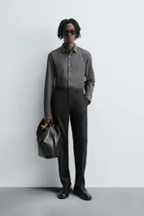Pantalón de vestir negro de lana, corte recto, con bolsillos laterales y traseros de ojal con botón.