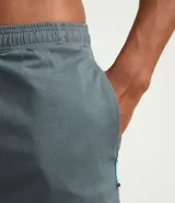 Bermuda deportiva masculina gris con cintura elástica, bolsillos laterales y cordón de ajuste.