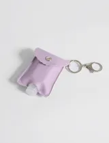 Llavero con funda de cuero sintético color lila que contiene un pequeño frasco.