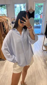 Camisa color beige de lurex, de corte holgado y mangas largas con puños abotonados.