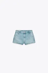 Shorts de jean celeste de tiro medio con trabillas, bolsillos laterales y traseros. Cierre frontal con cremallera y botón metálico.