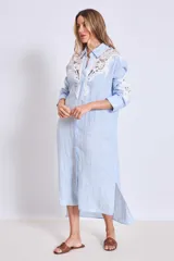 Vestido camisero celeste de lino con apliques de encaje blanco en cuello, mangas y frente.