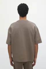 Remera color marrón topo de punto de algodón pesado, corte oversized, cuello redondo ribeteado, hombros caídos y bajo recto.