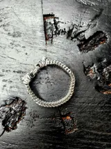 Pulsera de acero inoxidable con diseño de cabeza de lobo y enganche tipo pinza, de 22 cm de largo y 1 cm de ancho.