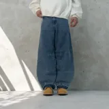 Pantalón jean azul de corte ultra baggy, con bolsillos traseros con diseño de llamas y terminación desflecada.