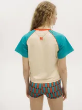 Remera colorblock con mangas ranglan color naranja, cuerpo blanco y cuello amarillo.