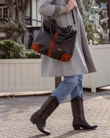 Bota de cuero marrón con caña alta de gamuza bordada.