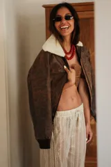 Pantalón de tejido de punto abierto color crudo, con cintura elástica y cordón ajustable.