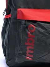 Mochila Umbro color celeste con detalles en gris. Presenta el logo de la marca en el frente y un bolsillo frontal con red. Tiene correas ajustables y cierre con cremallera.