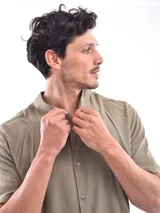 Camisa de corte clásico y manga corta, color verde militar, con cierre frontal de botones.