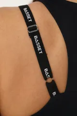 Top deportivo negro con espalda cruzada, tiras regulables y elástico, diseñado para ofrecer soporte durante entrenamientos.