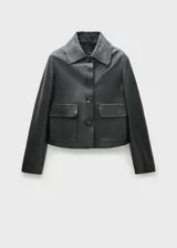 Chaqueta corta de cuero ovino color negro, con cuello camisero, cierre frontal con botones y dos bolsillos de solapa.