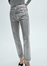 Pantalón de jean plateado de tiro alto, corte recto, con cierre de cremallera y botón, cinco bolsillos y trabillas.