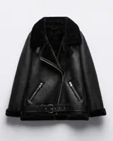 Campera negra de cuero sintético con interior de corderito sintético, cuello con solapas amplias, cierre cruzado con cremallera y cinturón con hebilla en la cintura.