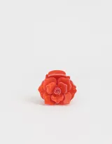 Broche para el pelo color naranja con forma de rosa.