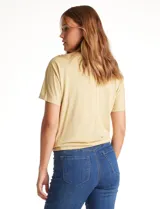 Remera color amarillo claro de modal, marca Philosophy, con cuello volcado y manga corta.