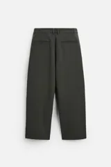 Pantalón relaxed fit color verde oscuro, con pliegues en la parte delantera, bolsillos laterales y traseros de ojal. Cierre frontal con cremallera y botón.