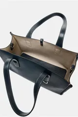 Bolso shopper azul marino con doble asa corta y correa larga de tela color crudo. Tiene detalle de pespuntes blancos y tira con anilla metálica.