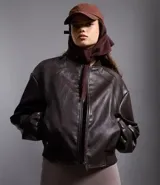 Campera bomber femenina de cuero sintético color marrón oscuro, con cuello alto, frisos en los hombros, puños y bajo ajustados, y cierre delantero con cremallera.