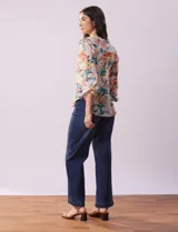 Blusa de gasa estampada con cuello a la base plisado y escote en V. Tiene apertura central con botones de nácar y mangas largas fruncidas. Incluye musculosa interna.