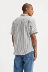 Camisa de manga corta a rayas verticales grises y blancas con bolsillo en el pecho izquierdo y logo de la marca en rojo.