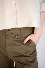 Pantalón de trabajo verde oliva, de tiro medio, confeccionado en gabardina de algodón. Presenta cinta utilitaria trasera, cintura ajustable, bolsillo para metro bordado y cinta reflectiva en los bajos.