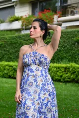 Vestido largo de gasa con estampado floral en tonos azul y dorado, con escote recto y tirantes finos cruzados en la espalda.
