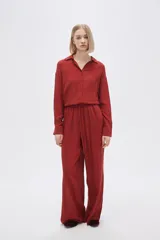 Pantalón negro ancho de viscosa con bolsillos laterales y cintura alta con cordón ajustable.