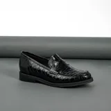 Mocasín de cuero vacuno color marrón, con detalle de antifaz en gamuza. Tiene taco de madera foliado en cuero de 2,5cm y entre suela de goma de 1cm.