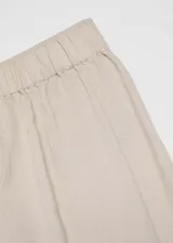 Pantalón crop color beige de tejido mezcla de lino, diseño wideleg y cintura elástica.