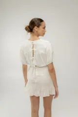 Minifalda marrón de lino con cintura alta y volado en el ruedo.