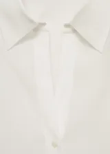 Camisa celeste de tejido fluido con cuello camisero, cierre frontal con botones y mangas largas con puños abotonados.