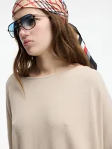 Sweater color crema de mangas 3/4, fit amplio y largo más largo en la parte trasera.