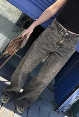 Pantalón jean azul oscuro, de corte wide leg y tiro medio. Presenta detalles de costuras diagonales en la parte superior.