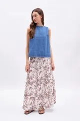 Pollera larga de mujer, con paneles y estampado abstracto en tonos marrones sobre fondo crudo.