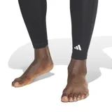 Calza de compresión negra, de corte largo, diseñada para entrenamiento y actividades deportivas.