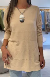 Sweater color beige, de punto, con cuello redondo y bolsillos en el frente.