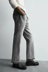 Pantalón de jean celeste de corte flare, con cinco bolsillos, efecto lavado y bajo con acabado irregular.