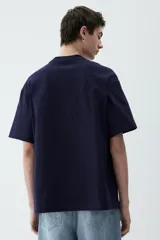 Remera azul marino de punto de algodón pesado, con cuello redondo ribeteado, hombros caídos y bajo recto. Corte holgado.