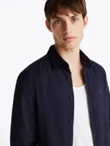 Camisa Tommy Hilfiger de manga larga azul marino, corte slim y cuello abotonado. Confeccionada en mezcla de algodón y poliéster.